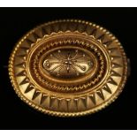 A Victorian gold oval brooch with applied decoration in a classical inspired design, the back glazed
