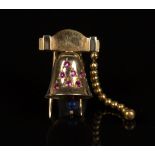 A French gold and ruby clip brooch, designed as a bell, the front mounted with seven cushion