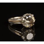 A two colour gold and champagne coloured diamond single stone ring, claw set with a circular cut