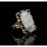 A gold ring, mounted with an oval opal in a rectangular surround, decorated with a foliate and