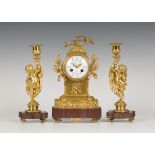 A late 19th century French ormolu and rouge marble clock garniture, the clock with eight day