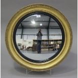 A 19th century gilt convex circular wall mirror, the deep moulded frame with an ebonized inner slip,