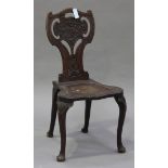 A late Victorian mahogany hall chair, the shaped back with a carved panel of a bird above a solid