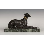 A late 19th/early 20th century brown patinated cast bronze model of a recumbent greyhound with a