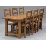 A late 20th century French oak dining table, the rectangular top above two drawers, raised on