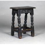 A 17th century oak joint stool with a carved frieze, raised on turned and block legs, height 55cm,