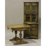 A 20th century oak draw-leaf dining table, raised on carved cup and cover supports, on bracket feet,