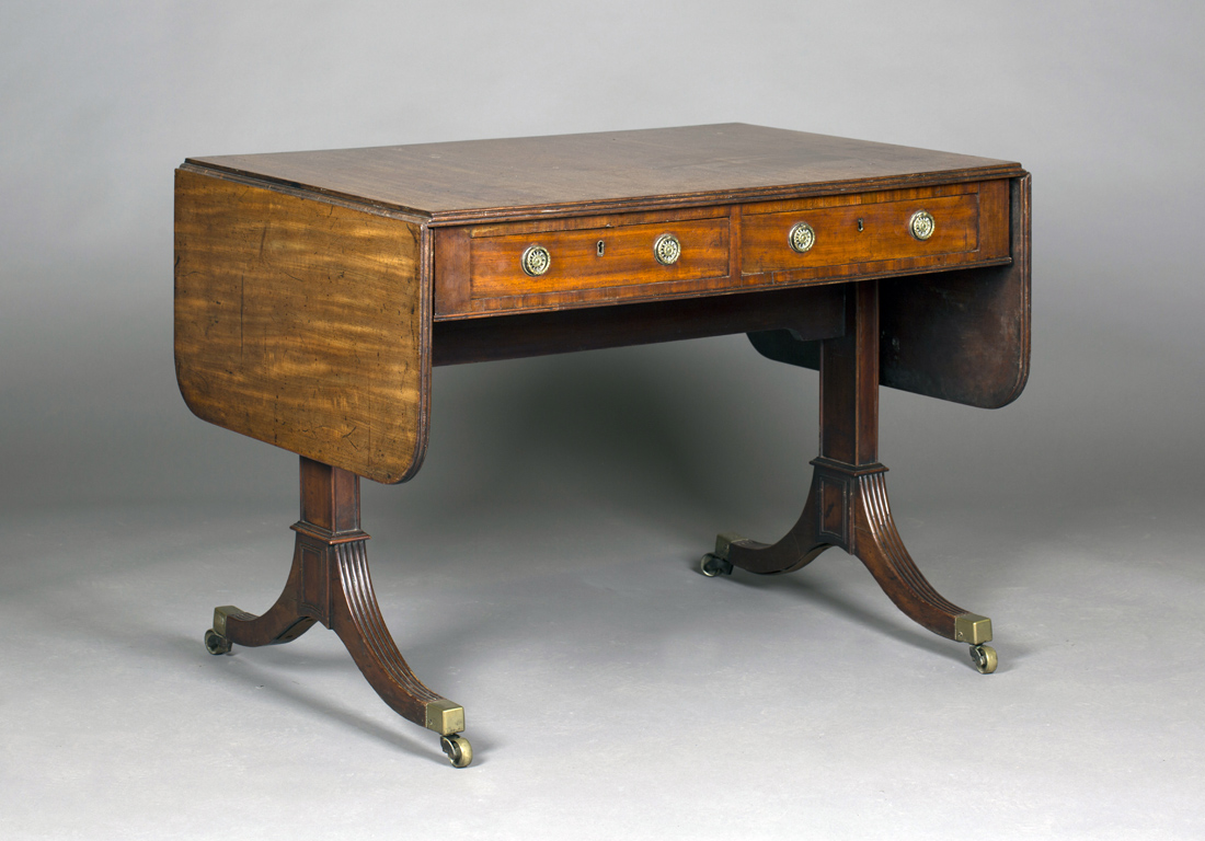 A late George III mahogany sofa table, the double-hinged top above two frieze drawers and a pair