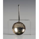 An Arts and Crafts style silver caddy spoon, the circular bowl with hammered decoration, the