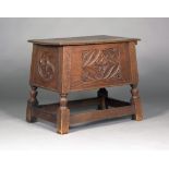 An early 20th century Gothic Revival oak chest, the hinged lid above carved tracery and rosette