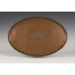 An Arts and Crafts copper oval tray by Hugh Wallis and a similar smaller example, both engraved with