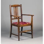 An early 20th century Arts and Crafts style oak rail back elbow chair, in the manner of Morris & Co,