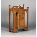 An Edwardian Arts and Crafts oak hallstand, fitted with a single drawer and a panelled cupboard