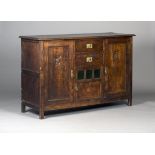 An early 20th century Arts and Crafts oak sideboard, the moulded top above two drawers and three