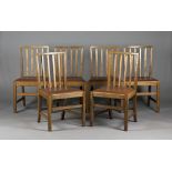 A set of six Arts and Crafts Cotswold School oak comb back dining chairs, designed by Edward