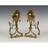 A pair of early 20th century Arts and Crafts brass fire tool rests, the roundel finials above