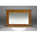 An Edwardian Arts and Crafts oak overmantel mirror, possibly retailed by Liberty & Co, the