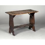 A late 19th century Arts and Crafts walnut centre table, the rectangular top carved in relief with
