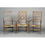 A group of three early 20th century Arts and Crafts beech framed elbow chairs, the turned spindle