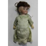 A Heubach bisque head doll, impressed '9578 N 5/0', with brown wig, closing blue eyes and bent