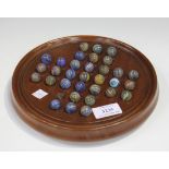 A Jacques mahogany solitaire board, diameter 21cm, and marbles, mostly with coloured swirls,