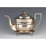 A George III silver teapot and stand, the teapot of cushion form with engraved foliate band, the