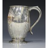 An Art Deco silver tankard, the swollen ovoid body engraved with four vertical striped bands,