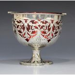 A Victorian silver sweetmeat basket with cranberry glass liner, the twisted overhead swing handle