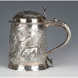 A Queen Anne silver tankard, the slightly tapered cylindrical body later embossed and chased with