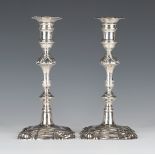 A pair of George II silver candlesticks, each with a detachable nozzle and turned urn shaped