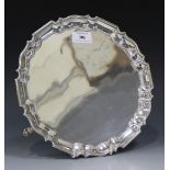 An Edwardian silver circular salver with piecrust rim, on hoof feet, London 1905 by Goldsmiths &