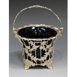 A Victorian silver sugar basket, the overhead pierced and floral cast swing handle, the circular