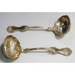 A pair of American sterling sauce ladles with foliate decorated oval bowls and foliate and reeded