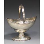 A George III silver boat shaped sweetmeat basket, the reeded overhead swing handle above a reeded