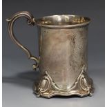 A Victorian silver christening mug of cylindrical form, with engraved vacant cartouche, flanked by a