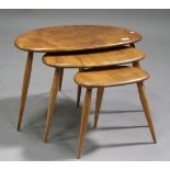 A mid-20th century Ercol nest of three tables, the shaped elm tops raised on turned legs, height