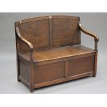 A George V oak box seat settle, the arched back with downswept arms and bobbin turned supports,