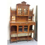 A late Victorian walnut side cabinet, the carved pediment above a glazed cupboard flanked by