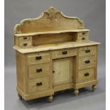 An early 20th century stripped pine sideboard, the shaped back fitted with four drawers, the base
