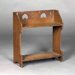 An Edwardian Arts and Crafts oak two-tier bookshelf, the gallery back with two pierced inverted