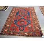 A Kazak rug, West Caucasus, early 20th century, the blue field with red stylized palmettes and