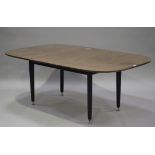 A mid-20th century G plan mahogany extending dining table with single extra leaf, raised on ebonized