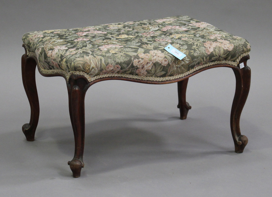 A Victorian walnut footstool with overstuffed floral seat, on carved cabriole legs, height 40cm,