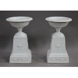A pair of 20th century white painted cast iron garden urns and stands, height 85cm, diameter 53cm.