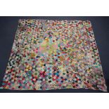 A mid-20th century patchwork bedcover, worked with overall polychrome hexagons, 250cm x 226cm,