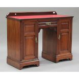 An Edwardian walnut twin pedestal desk, the red leather top above a drawer and two cupboards, raised