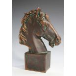 A 20th century coppered cast composition model of a horse's head, raised on a rectangular plinth,