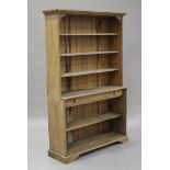 An early 20th century stripped pine open bookcase on bracket feet, height 202cm, width 125cm,