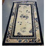 A Chinese rug, early 20th century, the ivory field decorated with flowering vines, within a