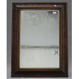 A 20th century walnut and gilt rectangular wall mirror of cushion section form, 87cm x 64cm. Buyer’s